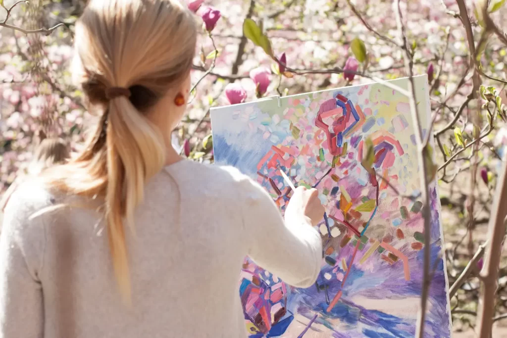 woman-in-white-long-sleeve-shirt-holding-white-and-blue-floral-painting